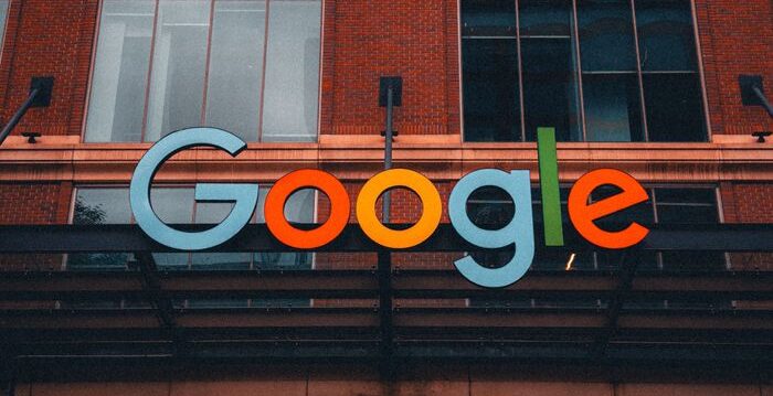 Colorful Google logo on modern building exterior in urban environment.